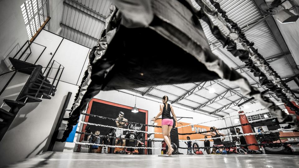 Inside the gym: ring, heavy bags, and open training floor